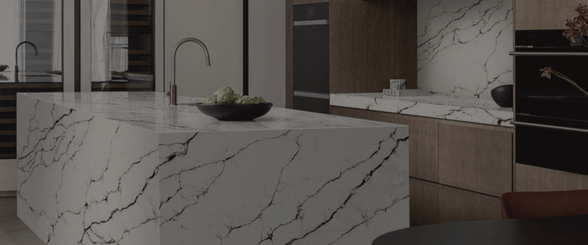Luxury kitchen featuring white marble-look slab countertops and island by Builder Stone Global